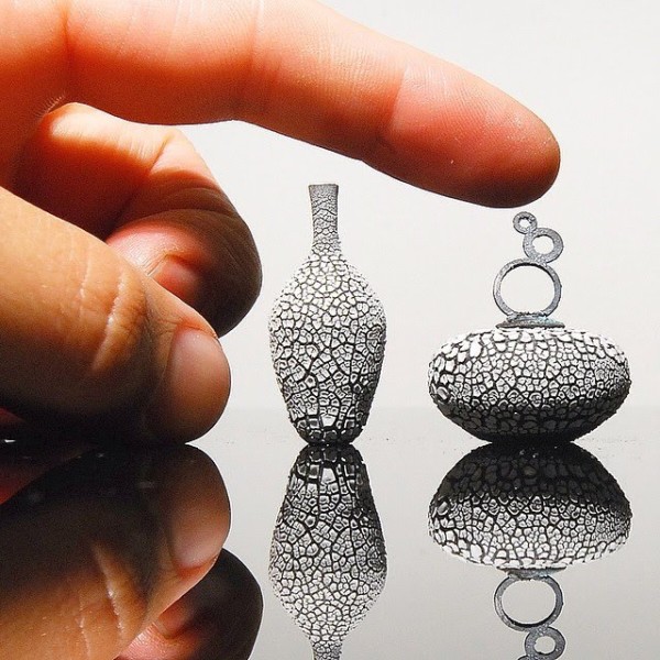 فنان يبدع في تشكيل القطع الفخارية بالغة الصغر