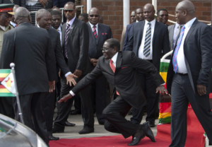 Zimbabwean President Robert Mugabe, center, falls after addressing supporters upon his return from an African Union meeting in Ethiopia, Wednesday, Feb. 4, 2015. Mugabe, 90, was elected chairman of the African Union and is set to celebrate his 91st birthday on Feb. 21. (AP Photo)