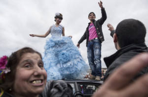 A Roma couple dances on the roof of a car in order to publicly announce their engagement in the Bulgarian city of Stara Zagora. Every year members of the widely dispersed Kalaidzhi clan have a meeting, called the "Gypsy Bride Market" in order to arrange matches and negotiate bride prices.